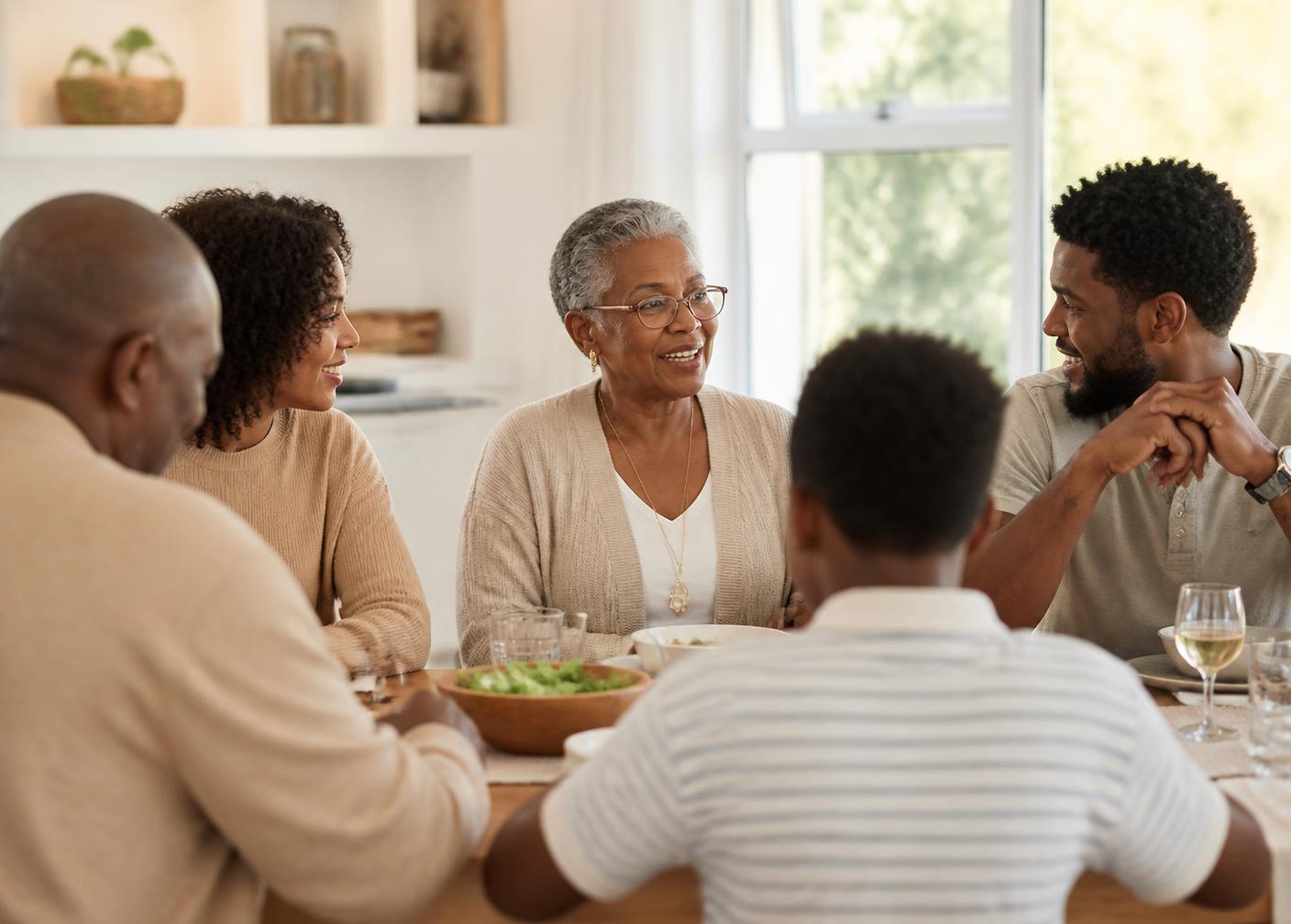 A multi-generational family talking together warmly around a dining table